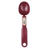 A maroon digital kitchen scale with a round, glossy measuring spoon attachment.
