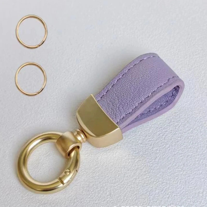 Lila Leder-Schafe-Auto-Schlüsselanhänger mit goldfarbenem Metallring und Spaltdesign.