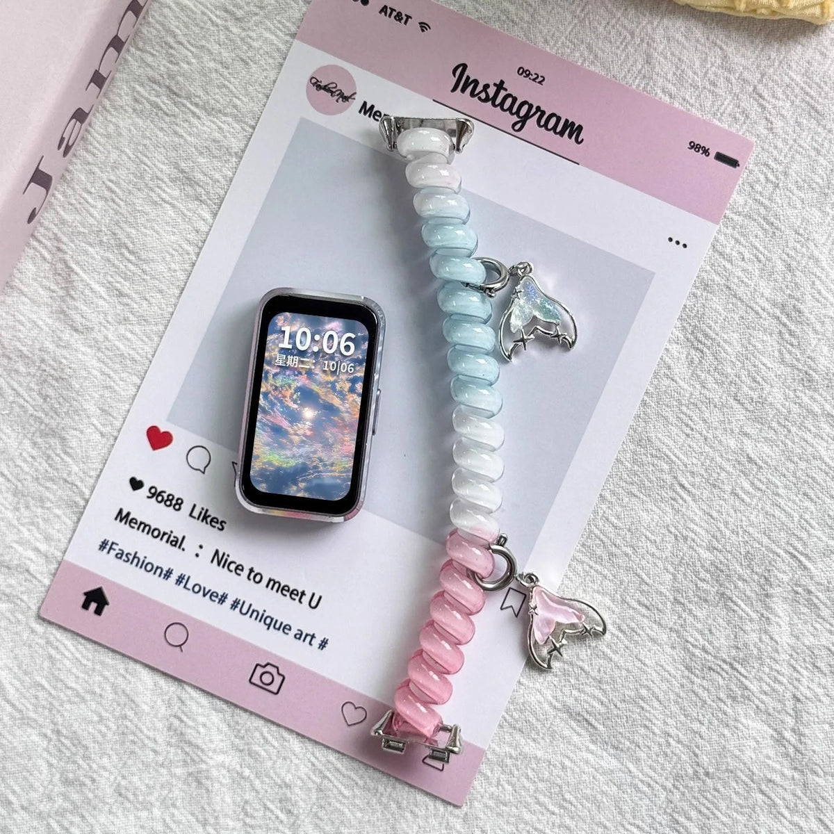 A close-up photo of a light blue and pink beaded replacement elastic watch strap for Huawei bands displayed on a pink Instagr