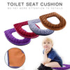A collection of colorful plush toilet seat cushions in various shades including purple, red, gray, and brown.