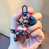 A hand holds a shiny metallic balloon dog keychain charm with a hook and pearl accents.