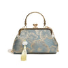 A light blue embroidered silk evening clutch with gold chain strap and tassel detail.