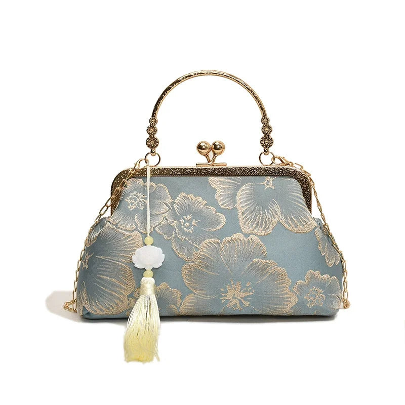 A light blue embroidered silk evening clutch with gold chain strap and tassel detail.