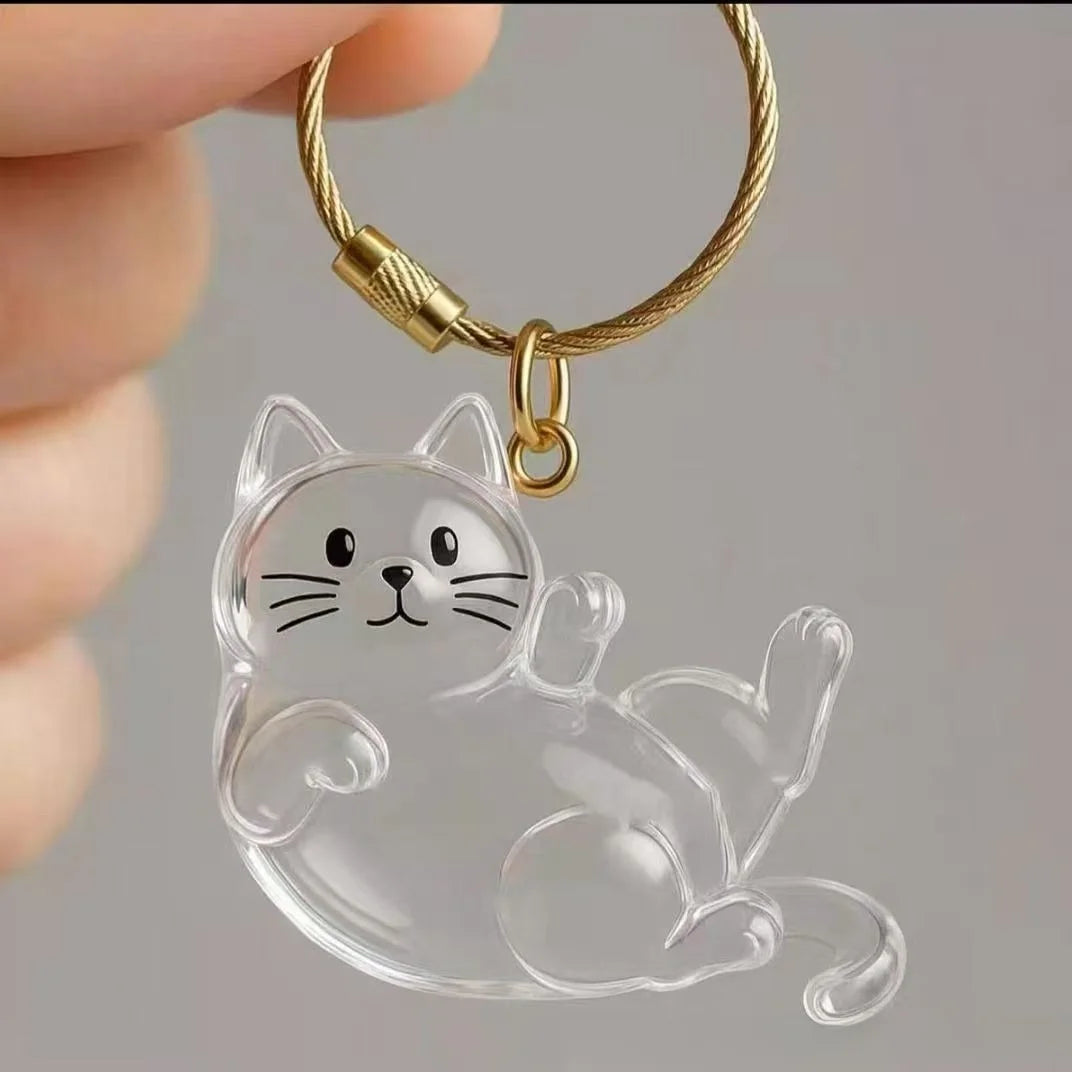 A clear silicone cat pendant keychain with gold-colored chain attached.