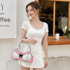 A woman models a pink and white polka dot bow shoulder bag with a playful bra silhouette and a white mini skirt.