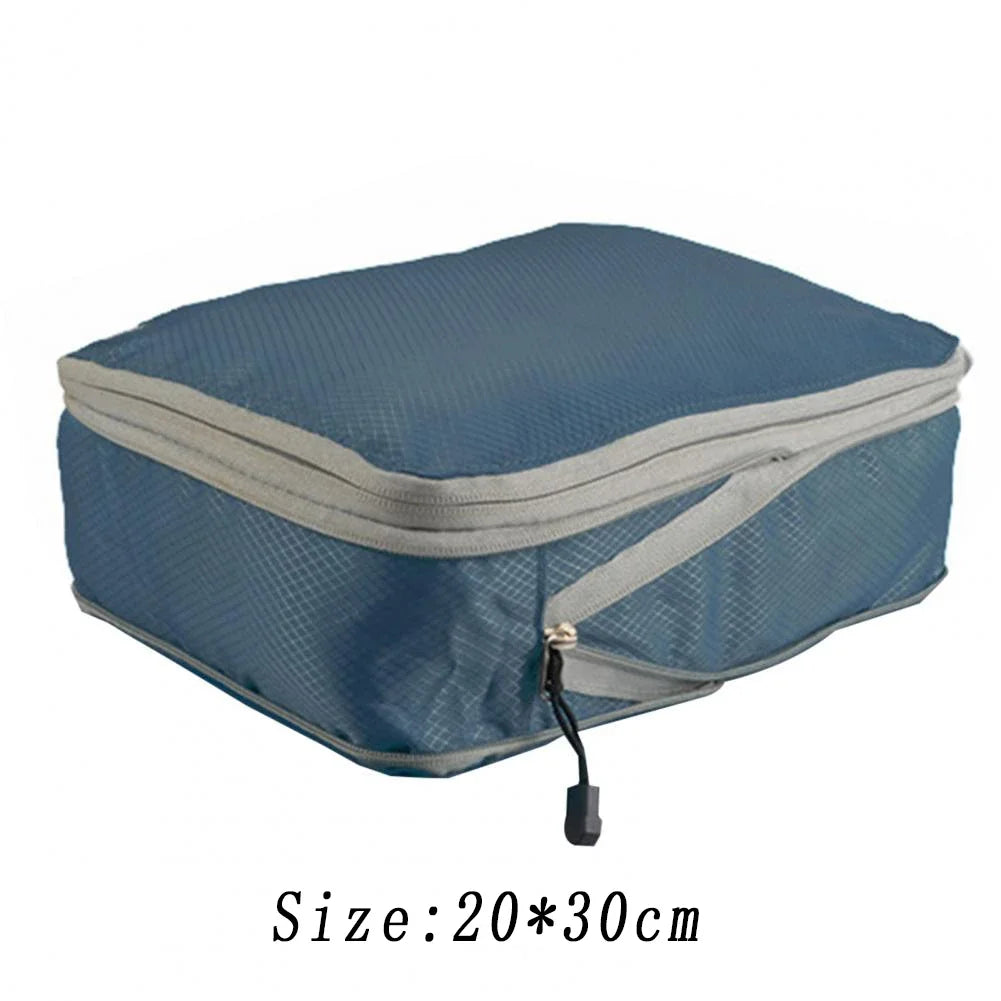 A blue reusable compression packing cube with a gray zipper and a black pull tab.