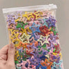 A clear plastic bag filled with a variety of colorful vintage star hair clips and barrettes
