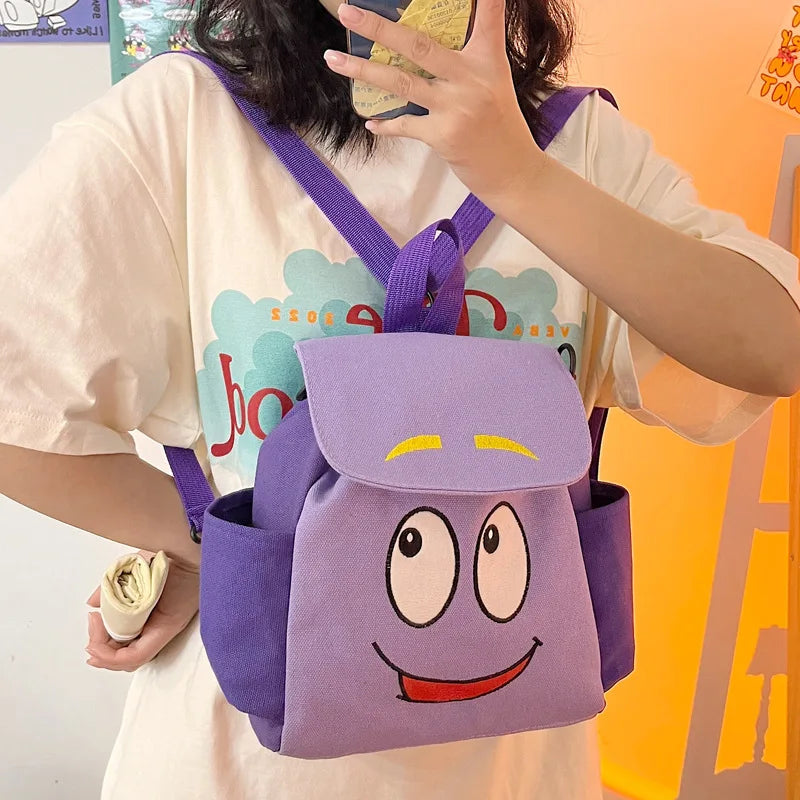 A purple Dora The Explorer cartoon flannel backpack being held by a person.