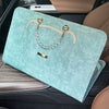 A light mint green slim PU laptop protective case with a gold chain strap resting on a car seat.