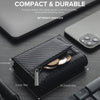Schwarzes Leder-Pop-up-Kreditkarten-Wallet neben einem Smartphone und einem Stift auf dunkler Oberfläche.
