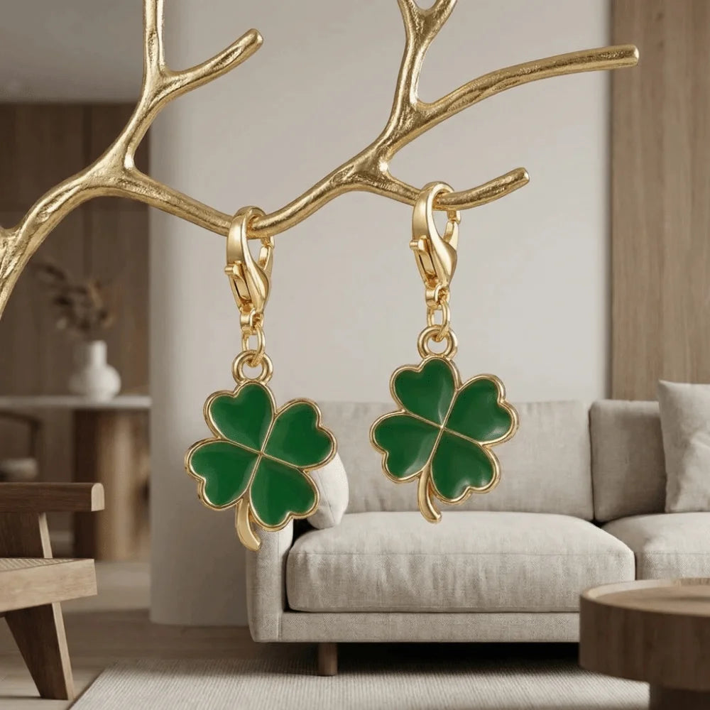 Gold branch shaped keychain with a green four leaf clover charm hanging against a light background.