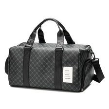 A black duffle bag with leather trim and handles is shown from the side.