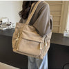 A beige corduroy shoulder bag with zipper details is shown hanging on a person's shoulder.