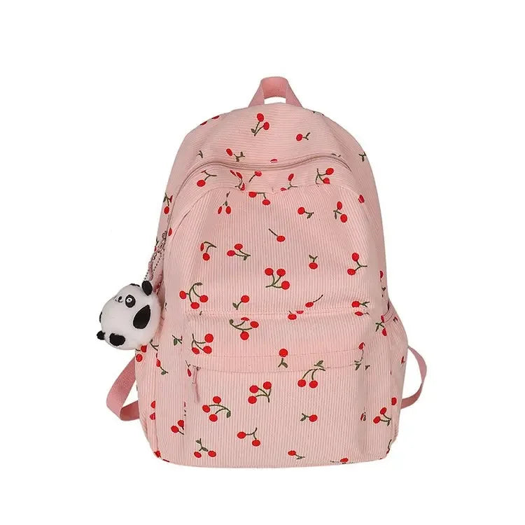A pink corduroy fashion backpack with a repeating floral pattern and a black panda charm.