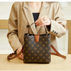 A woman holds a brown leather bucket bag with a floral pattern against a light background.
