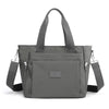 A gray durable nylon tote bag with padded straps and a secure zipper closure.