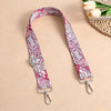 A pink and white bohemian printed crossbody strap with silver hardware is displayed on a neutral background.