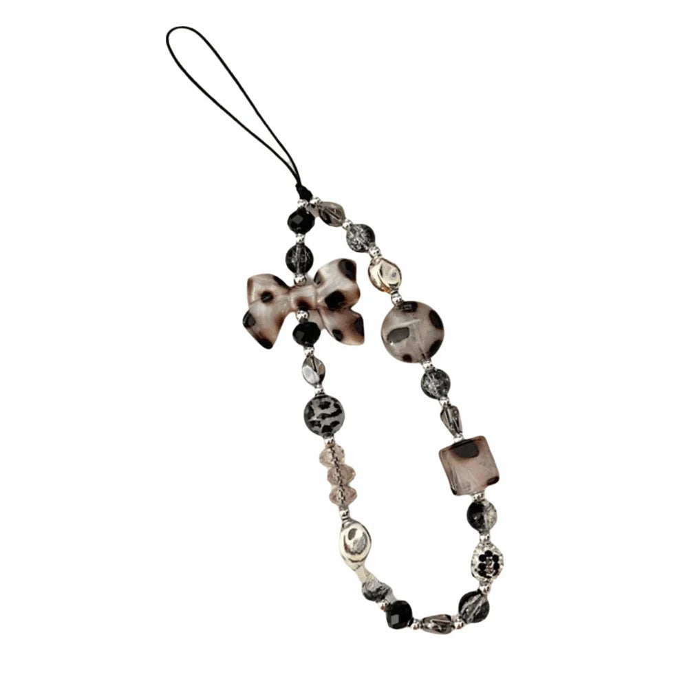 Leopard print bowknot phone lanyard featuring heart-shaped beads and a leather cord.