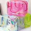 A pink and clear waterproof makeup organizer bag with glitter accents is displayed on a white surface.