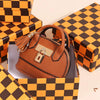 Portefeuille-clés en PVC marron de luxe présenté dans une boîte cadeau à carreaux noir et orange.