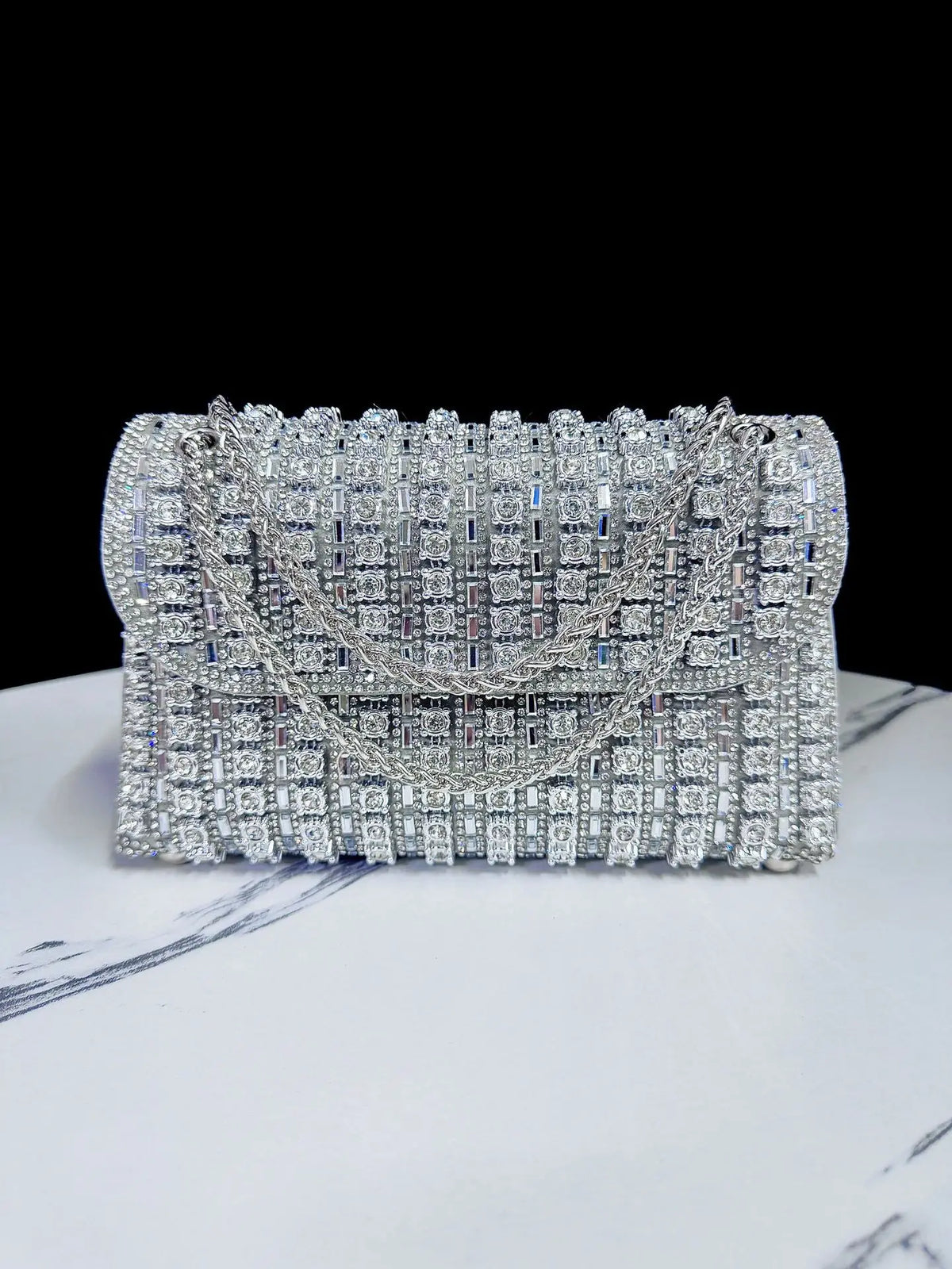 Silver rhinestone evening clutch bag featuring a diamond chain detail.