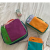 A purple and green alpaca three-piece storage bag set lying on a white surface.