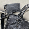 A black soft PU leather shoulder tote bag with a flap and leather strap is shown in a close-up view.