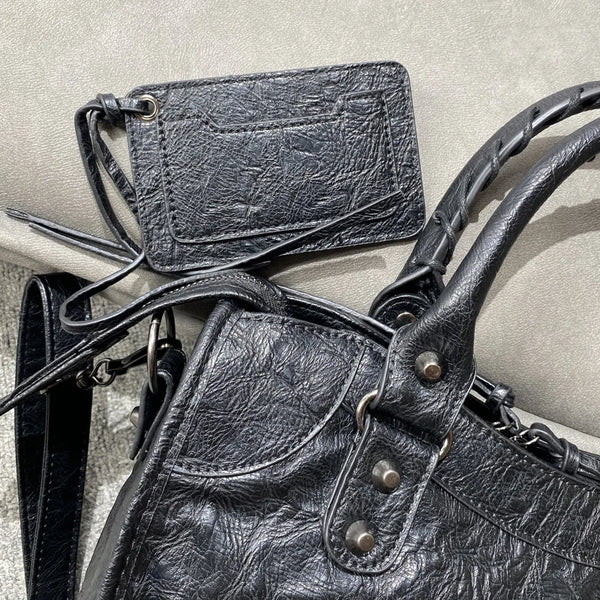 Bolso tote de cuero suave PU negro con solapa y correa de cuero en vista de cerca.