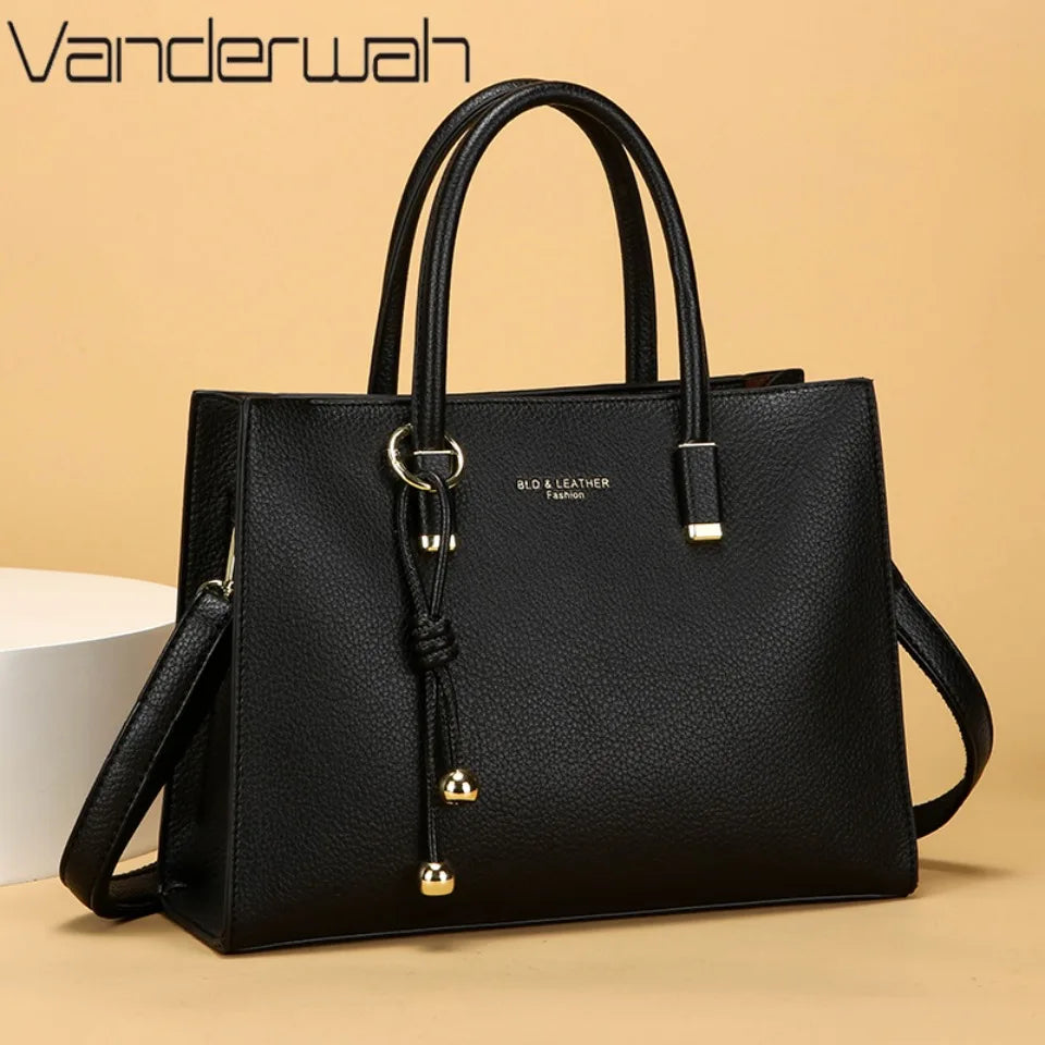 Schwarze Leder-Tasche mit goldenen Details vor neutralem Hintergrund.