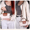 Una mujer modela una camisa beige y pantalones blancos mientras sostiene un mini bolso de cuero beige claro con correa marrón