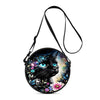A black cartoon cat round crossbody bag with a floral and starry design and a black strap.