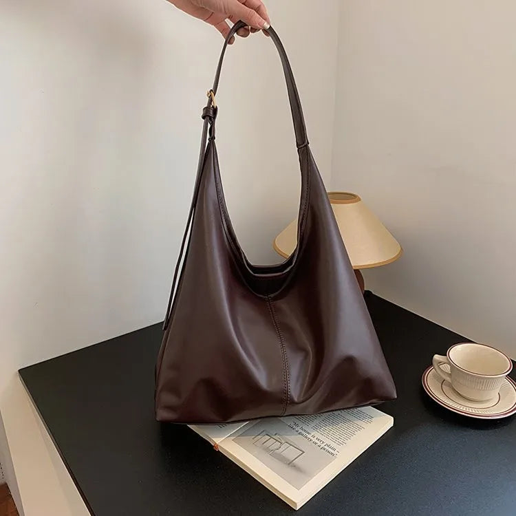 Ein brauner Retro-Canvas-Totebag wird auf einem dunklen Tisch neben einer Tasse und Untertasse präsentiert.