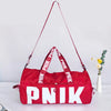 A bright red Nike PNIK shoulder bag with white lettering, shown against a light background.