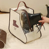 A beige canvas storage bag with a leather boot insert and a brown strap is shown on a white surface.