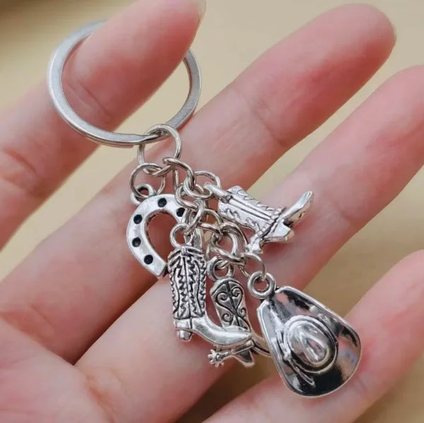 Silver keychain set featuring a cowboy boot, hat, and horseshoe charms