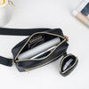 Schwarze gesteppte Crossbody-Tasche mit goldfarbenem Riemchen und Innenfutter auf weißem Untergrund.