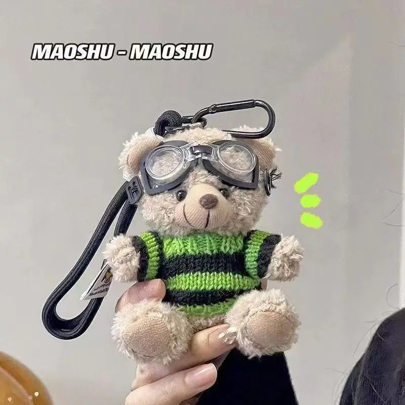 A fluffy bear plush toy is shown holding a camera and glasses, likely used as a keychain.