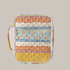 A quilted floral Bible cover in various pastel and earthy tones with a zipper and pen holder.