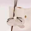 Estuche de gafas de cuero blanco con correa beige claro sobre fondo blanco.