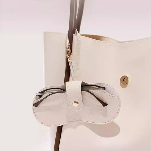 A white leather sunglasses pouch with a light beige strap is shown against a white background.