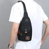 A person wearing a white t-shirt and black mask is holding a black compact oxford crossbody sling bag.