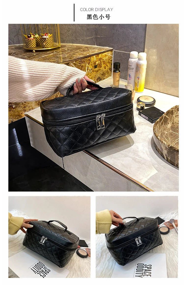 Black large capacity PU embroidery makeup storage pouch displayed on a marble surface.