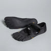 A pair of black women's barefoot five-toe shoes with an adjustable strap shown from the side.