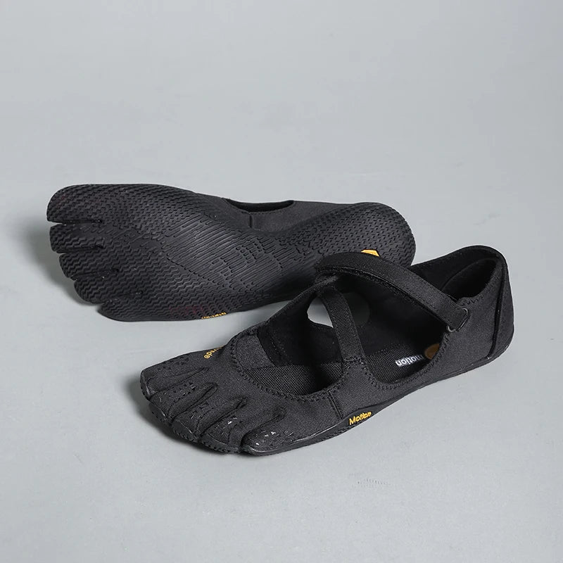 A pair of black women's barefoot five-toe shoes with an adjustable strap shown from the side.