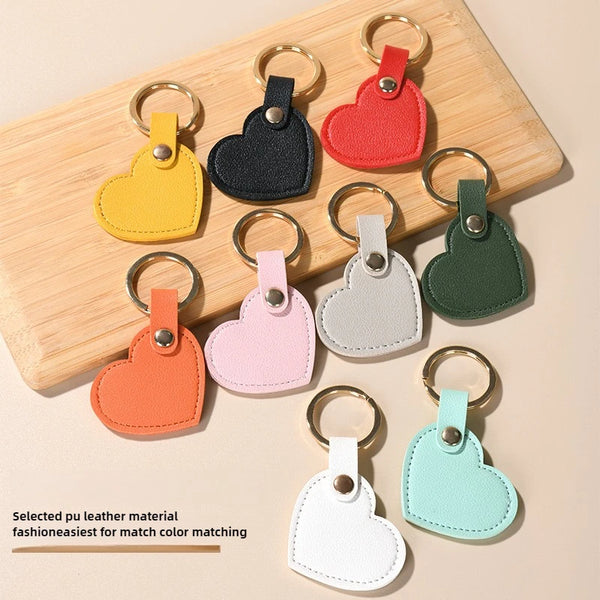 A collection of assorted color leather heart keychains arranged on a wooden board.