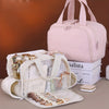 A pink portable side-zip cosmetic organizer bag with a clear mesh insert and brush set is displayed on a wooden surface.