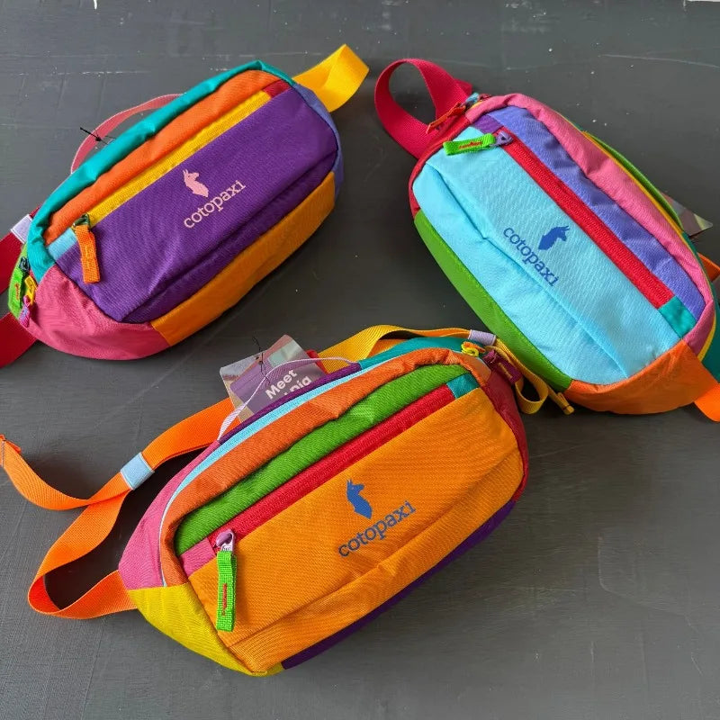 Drei farbenfrohe Outdoor-Sport-Crossbody-Taschen in Lila, Orange und Türkis auf einer dunklen Oberfläche.