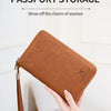 A brown leather multi-card slot passport storage holder being held by a hand.