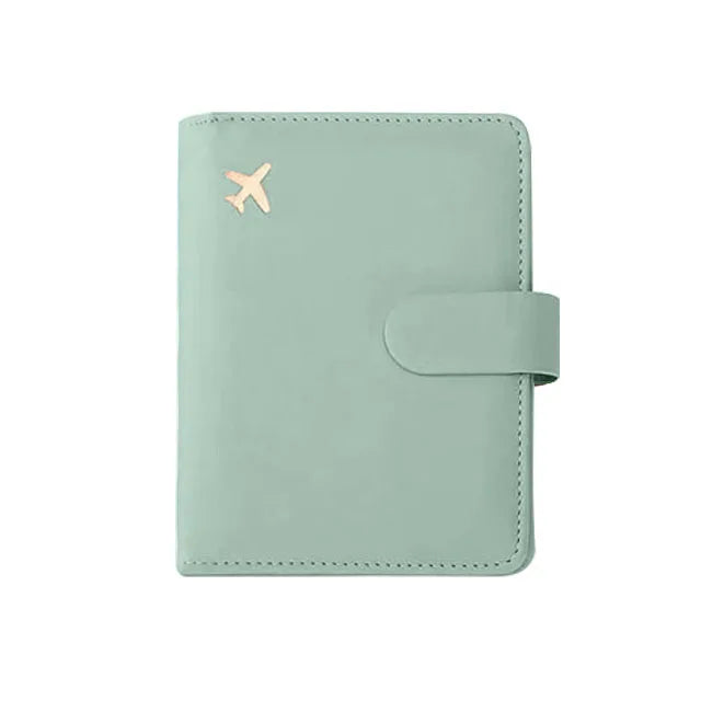 A light mint green RFID-blocking travel passport organizer with a leather cover and card slots.
