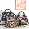 Bolsa térmica portátil marrón con estampado floral y leopardo, mostrada sobre una superficie blanca.
